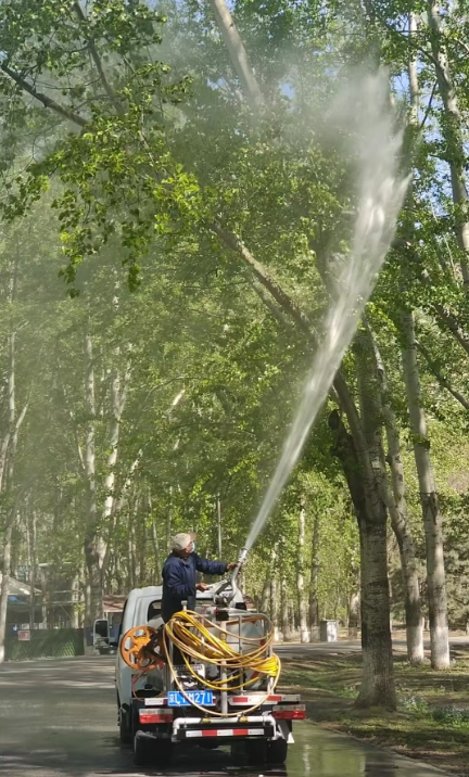 图为环卫工人在奥森公园北园对树木进行喷洒作业。尚玉.png